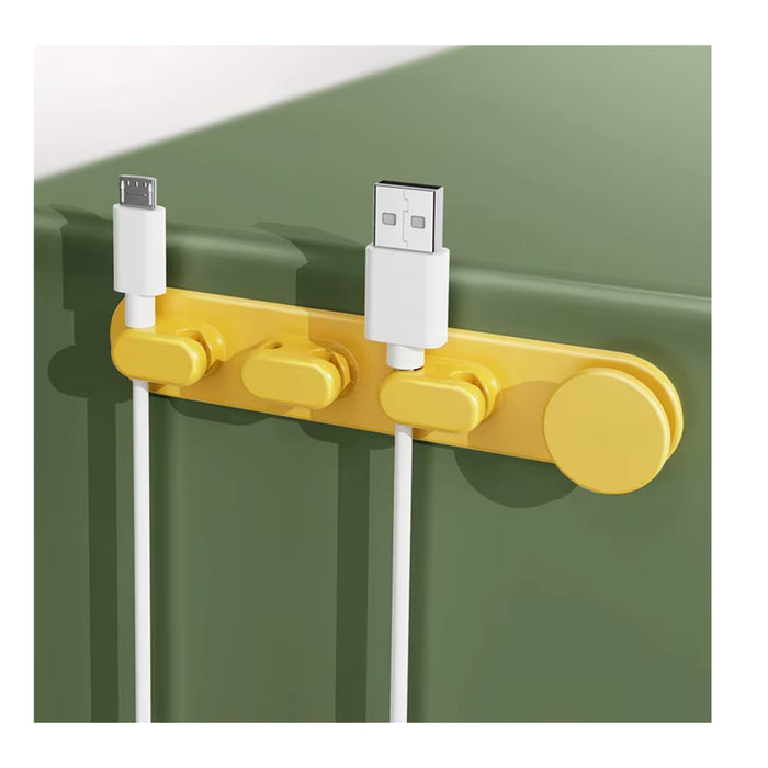 Yellow cable organizer holding USB and charging cables on a green surface