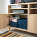 Open cabinet with KUGGIS boxes storing educational books like Algebra and Trigonometry, blending utility with neat aesthetics