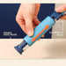Blue kitchen tool with modes for paring knife and sharpening, held by a hand.