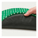 Hand holding a green and white patterned mat over a black textured surface