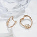 Pair of gold hoop earrings on a white fabric background