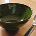 Extreme close-up of the bowl's vibrant green glazed surface showing the concentric textured rings.