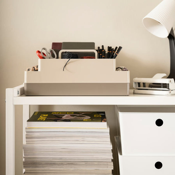 White desk with office supplies and a lamp in a minimalistic setting