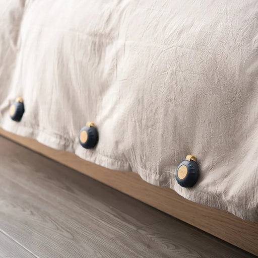 Close-up of a textured fabric surface with wooden buttons on a wooden base.