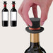 Hand placing black top hat-shaped silicone stopper into wine bottle neck – novelty design with red band for secure sealing – 1600002389866 13964736
