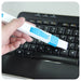 Hand holding a keyboard cleaning brush with blue bristles over a laptop keyboard.