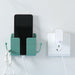 Green wall-mounted holder securing a smartphone and white charging cable; side hook holds white earphones—organized setup beside a wall socket, designed for multifunction charging and storage – 1598448185067 13069398.