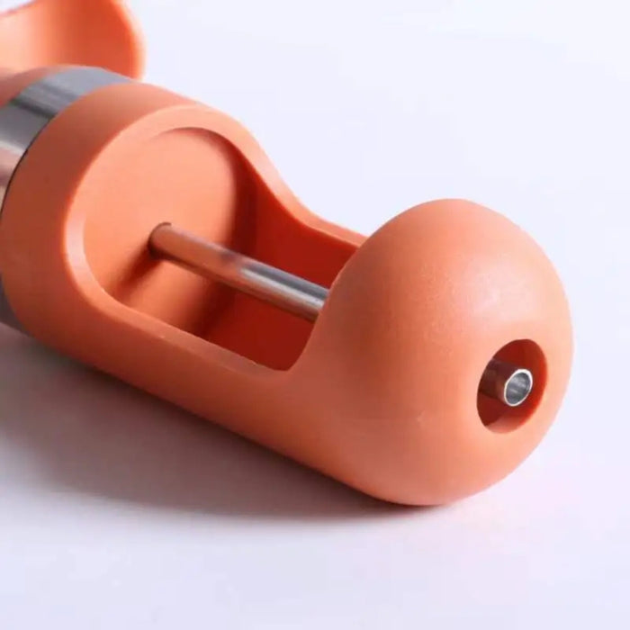 Close-up of orange jujube pitter with metal rod and chamber, highlighting efficient seed removal mechanism