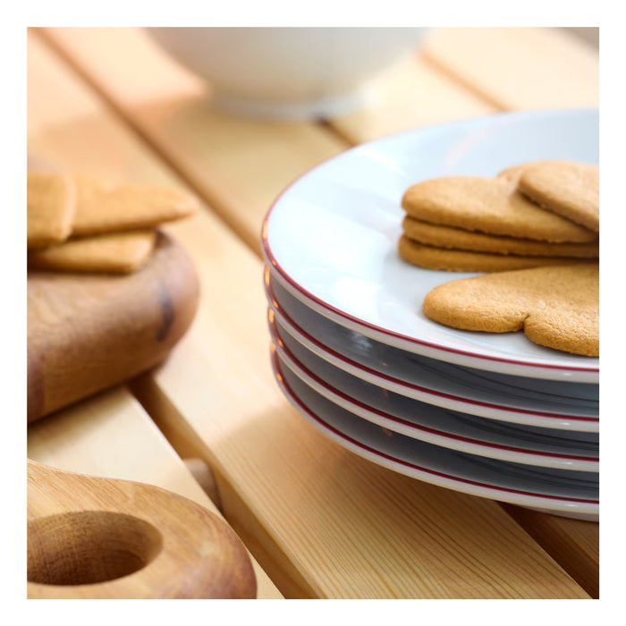 Stack of ceramic plates with striped design on a wooden surface