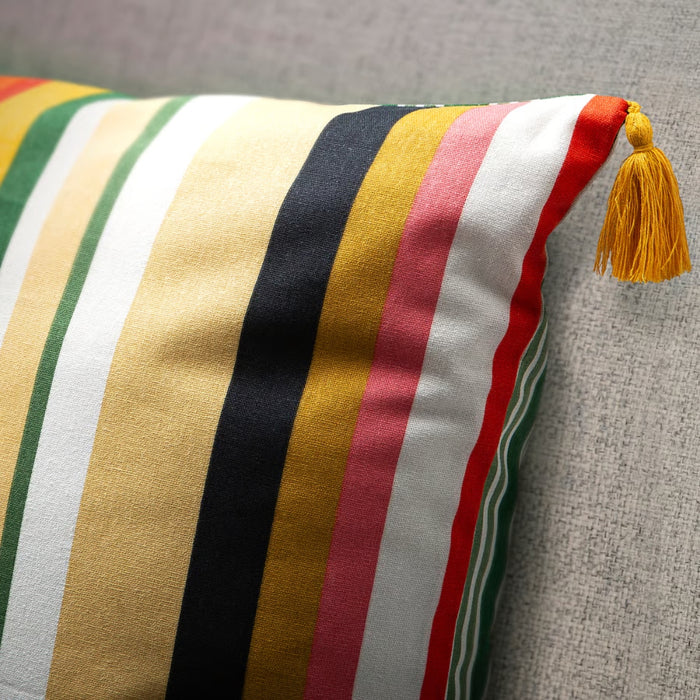 Striped pillow with a tassel on a gray surface