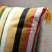 Striped pillow with a tassel on a gray surface
