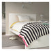 Bed with striped blanket in a bedroom setting