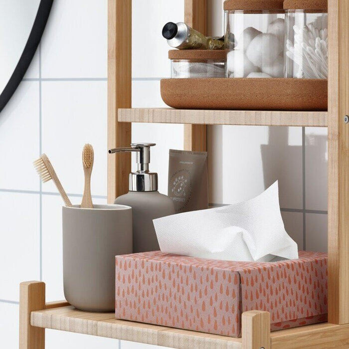 Bathroom shelf with various items including a tissue box, soap dispenser, and toothbrush holder.