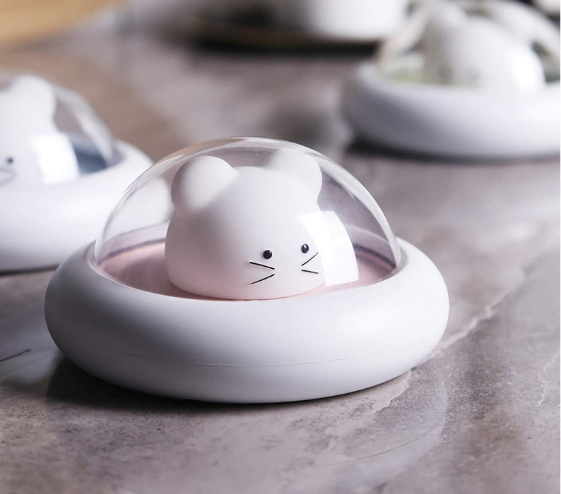 Cute white cat-shaped night light with a transparent dome on a gray surface.