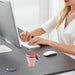 Person using a computer with a pink mug on a desk