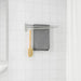Towel rack with a gray towel and a gold brush on a white tiled bathroom wall.