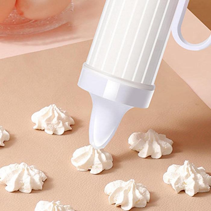 White piping gun dispensing decorative whipped cream dollops, ideal for festive cake and dessert decoration