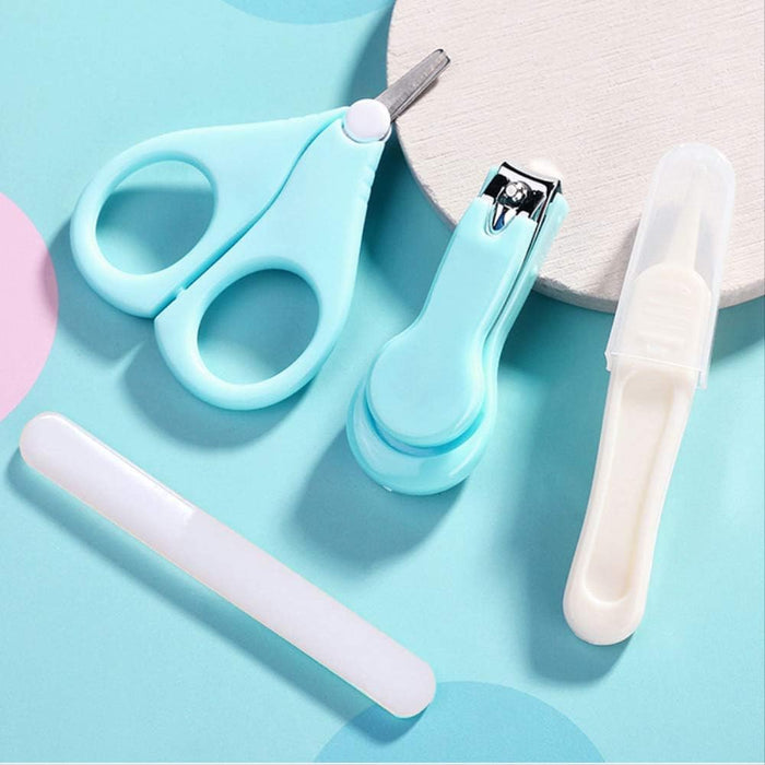 Set of baby grooming tools including scissors, nail clippers, and a brush on a light blue background.
