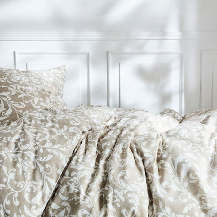 Close-up of beige and white patterned bedding with intricate floral design. Set includes a duvet cover and pillowcase, placed on a bed against a white paneled wall-00412614, 10424225 