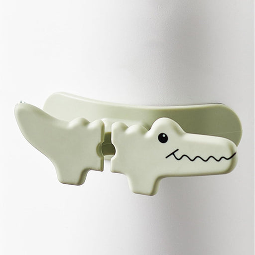 Light green alligator-shaped clip on a white background