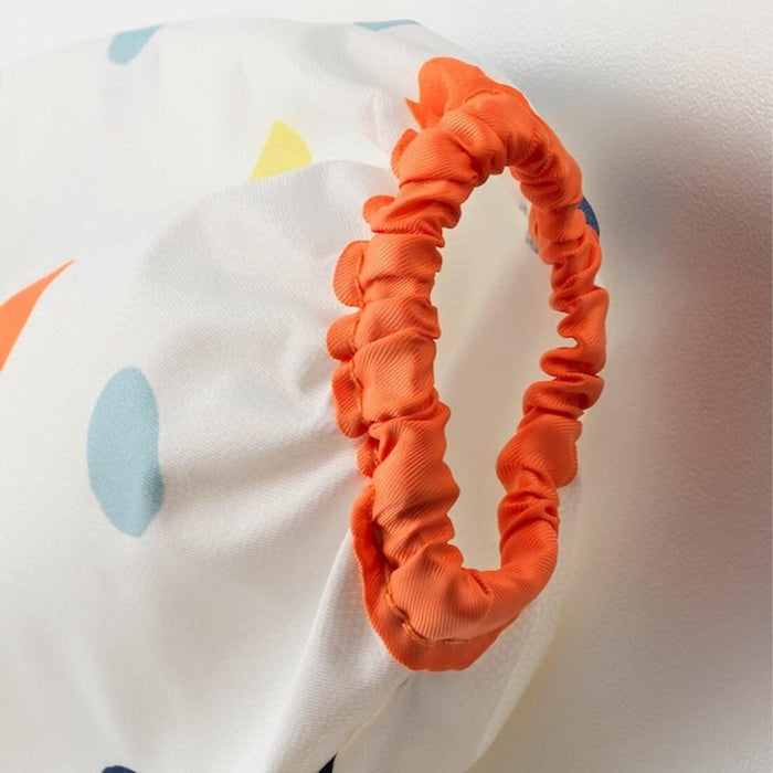 Orange scrunchie on a white background with colorful polka dots
