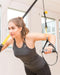 Woman exercising with TRX suspension straps indoors