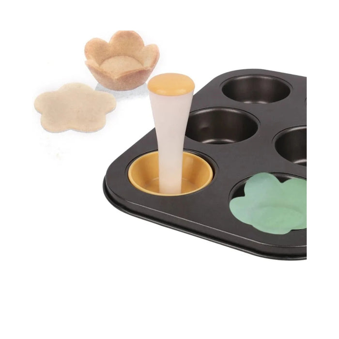 Baking tray with flower-shaped cookie cutters and a piping bag on a white background