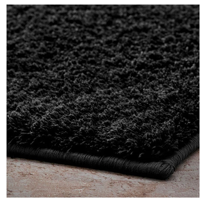 Close-up of a dark gray rug on a wooden floor