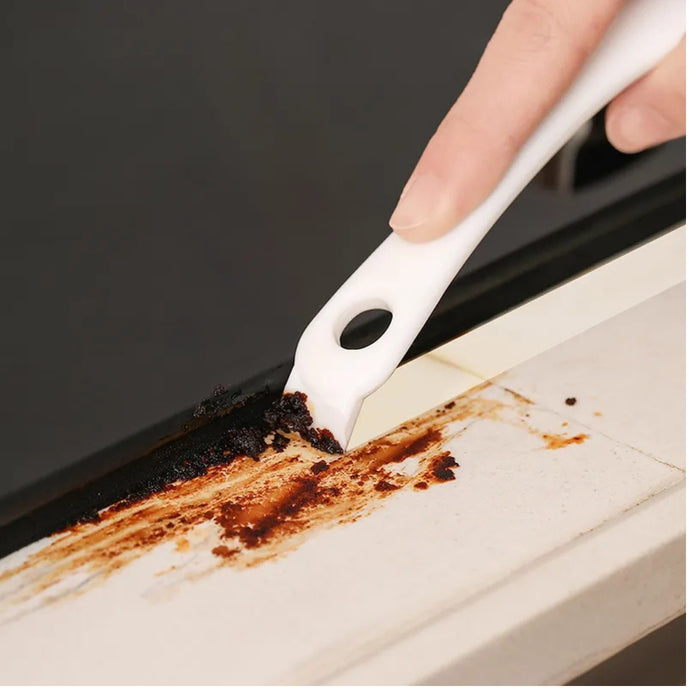 Digital Shoppy cleaning scraper – white plastic tool removing burnt residue from kitchen countertop
