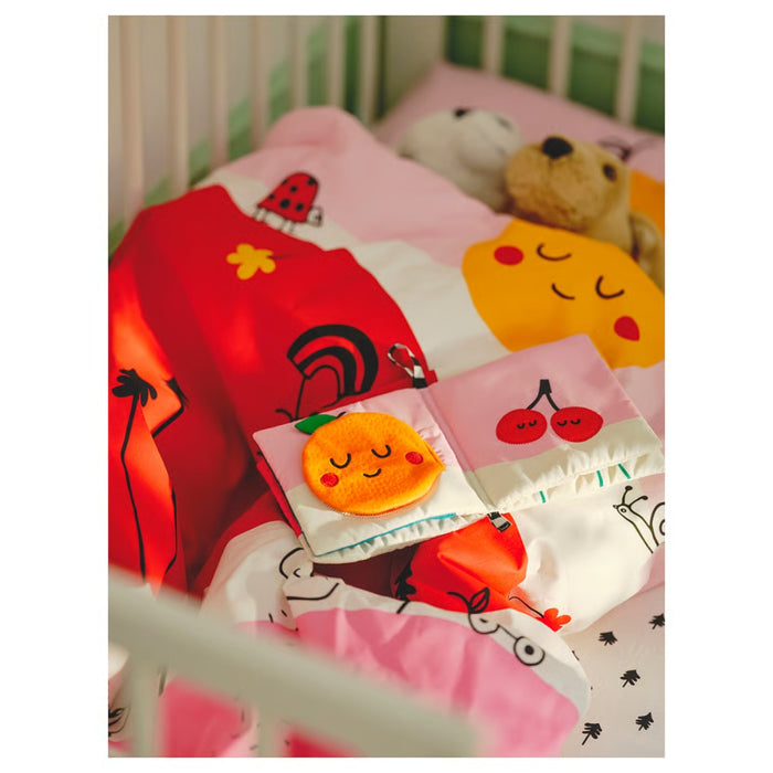 Children's bedding set with cartoon designs on a bed.