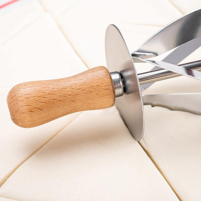 Pastry cutter with circular metal blade and wooden handle placed on triangular dough sections – precision tool for croissant prep – 553248 13955755