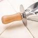 Pastry cutter with circular metal blade and wooden handle placed on triangular dough sections – precision tool for croissant prep – 553248 13955755