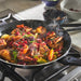 Stir-fry dish with vegetables and meat in a pan on a stove