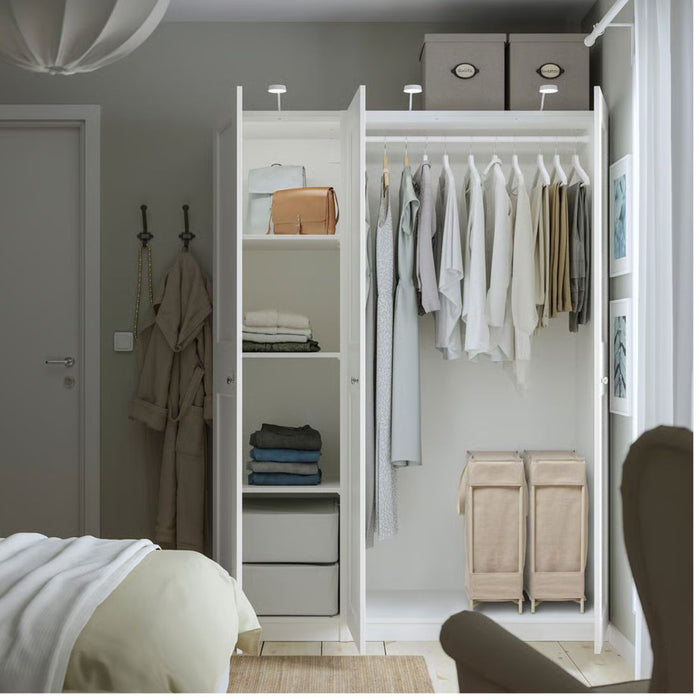 Open closet with clothes hanging and shelves in a bedroom setting