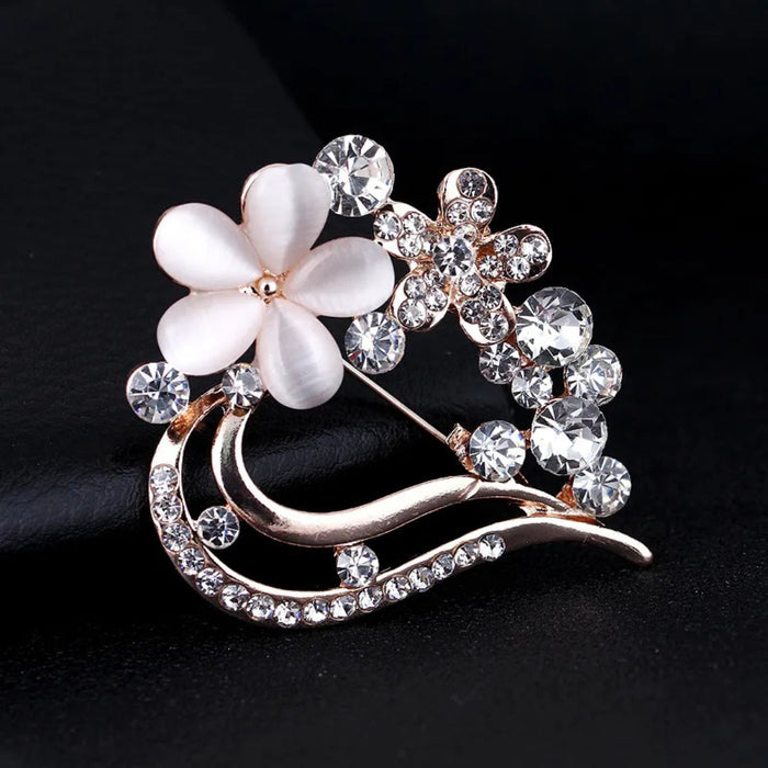 Digital Shoppy opal brooch – close-up of white petal and crystal brooch with curved metallic structure on black fabric