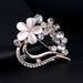 Digital Shoppy opal brooch – close-up of white petal and crystal brooch with curved metallic structure on black fabric