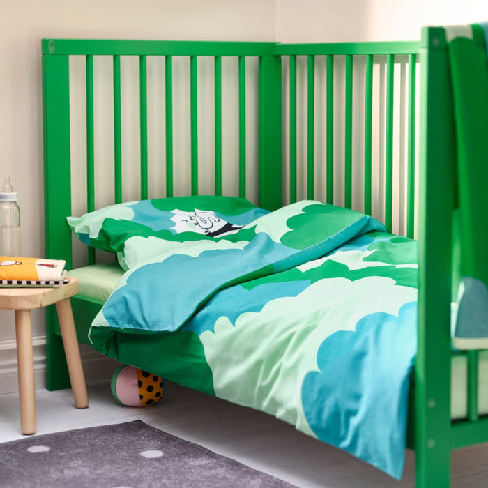 Green crib with matching bedding in a child's room