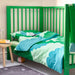 Green crib with matching bedding in a child's room