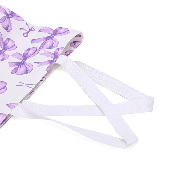 Canvas Shoulder Bag – Purple Bow Print, 15×6.5×13.5cm Fashion Tote, close-up of crisscross white straps and bow pattern
