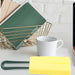 Yellow sponge brush with green handle placed on white desk near ceramic mug and wire basket – versatile cleaning tool for kitchen or workspace – 1598453485864 13972338