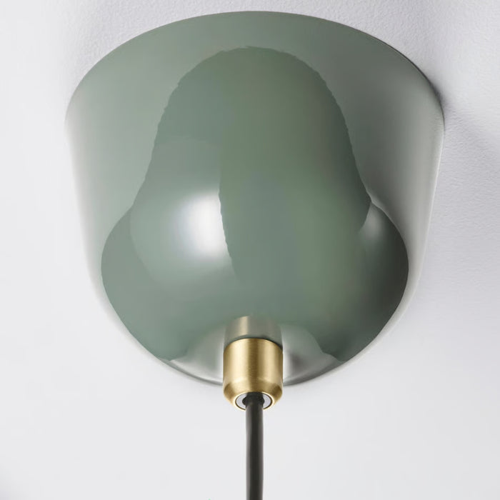 Detail view of RÖDFLIK lamp with engraved brass plate “MAX 15W” on green surface, highlighting functional design