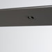 Close-up of a dark gray metal strip with two circular holes on a white background