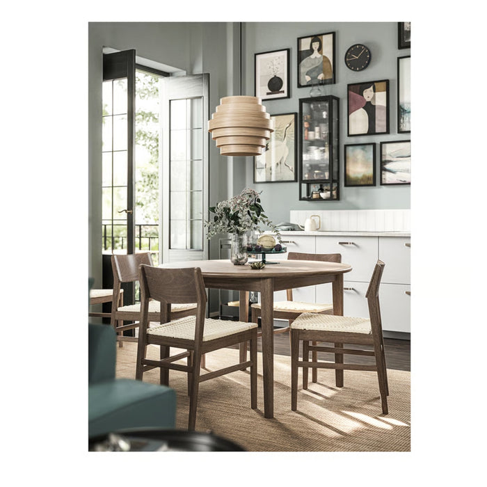 Dining room with wooden table and chairs, light fixture, and framed pictures on the wall.