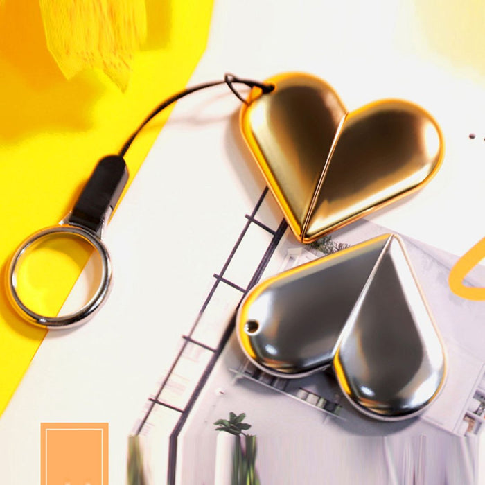 Women's stainless steel blade eyebrow trimmer in gold color. Features a heart-shaped design with a sleek black strap attached to a keyring. Compact and stylish for easy portability. Ideal for precise eyebrow grooming with a touch of elegance-
