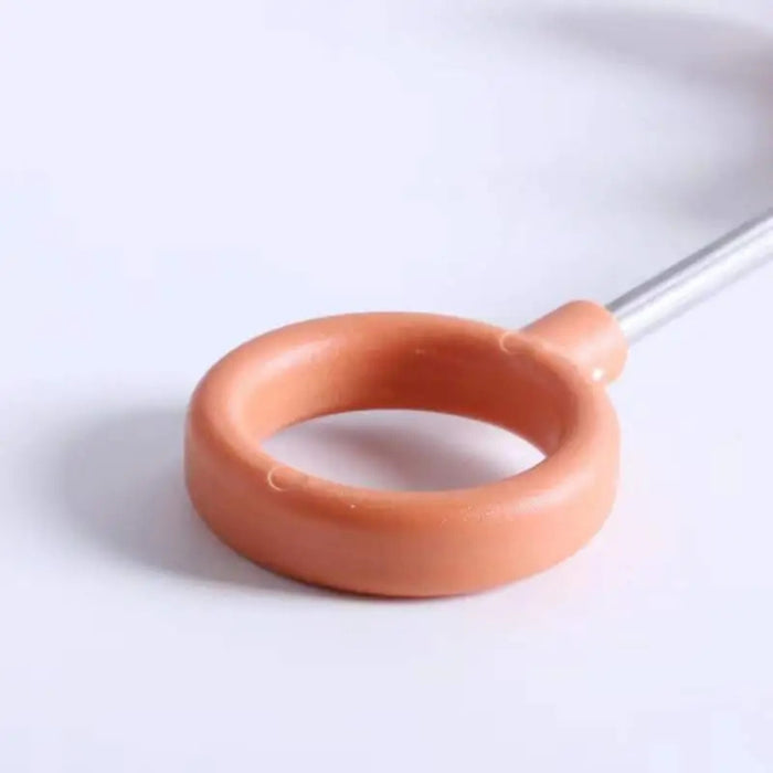 Peach-colored circular ring tool with metal handle, resembling a bubble wand or alternate seed ejector design