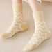 Feet wearing mango yellow zigzag socks resting on light surface with rolled-up white pants