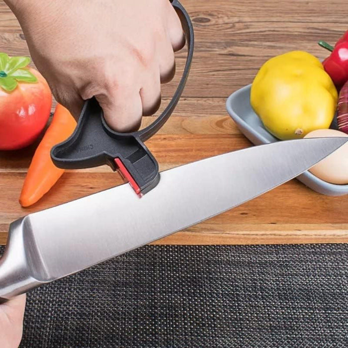 2-in-1 Knife & Scissor Sharpener – Handheld, ergonomic grip, black tool sharpening knife beside vegetables on table - 