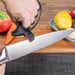 2-in-1 Knife & Scissor Sharpener – Handheld, ergonomic grip, black tool sharpening knife beside vegetables on table - 