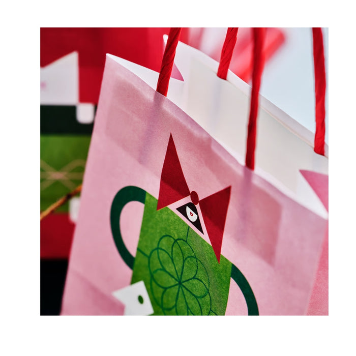 Colorful fabric with a green teapot design on a pink background