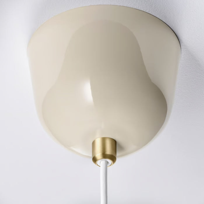 Close-up of the ceiling cup of the RÖDFLIK lamp in light beige with a stylish brass cord fastener.